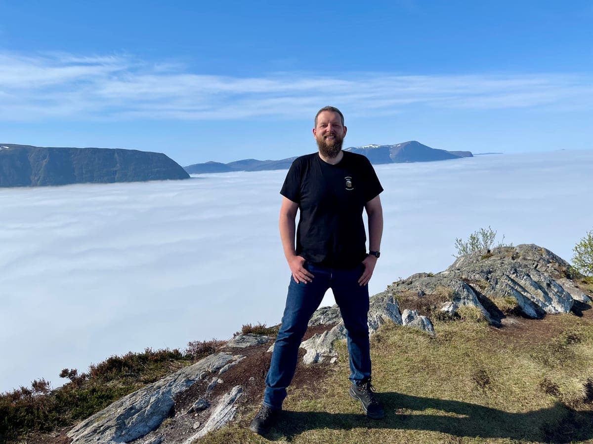 Florian auf einem Berggipfel über den Wolken